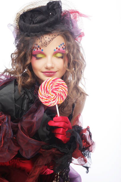 istock Girl with with creative make-up holds lollipop. 1567770104