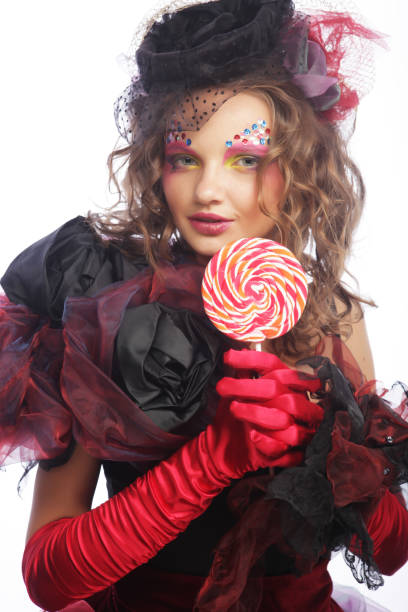 istock Girl with with creative make-up holds lollipop. 1567770106