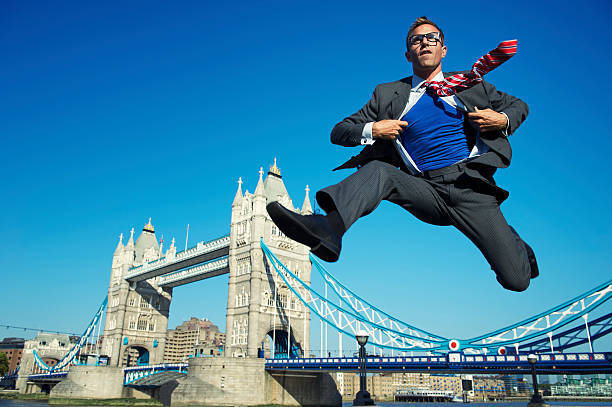 молодые супергерой бизнесмен, перепрыгивая через tower bridge london - hurdle people england tower bridge стоковые фото и изображения