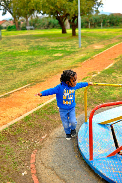 istock beautiful young black African boy with dreadlocks playing in a park . 1567776838