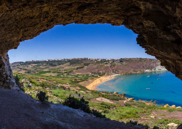 tranquila formación rocosa costera con cueva - gozo malta natural arch natural phenomenon fotografías e imágenes de stock
