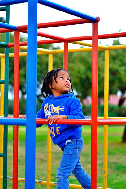 istock beautiful young black African boy with dreadlocks playing in a park . 1567789212