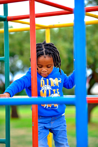 istock beautiful young black African boy with dreadlocks playing in a park . 1567792011