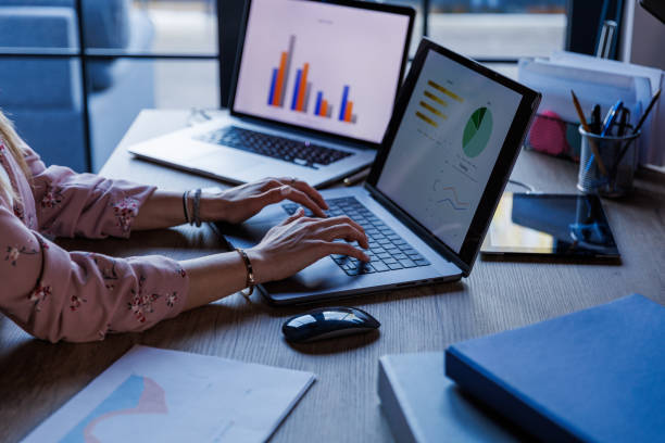 istock Businesswoman sitting at her desk, typing data on laptop when making a graph 1567794841