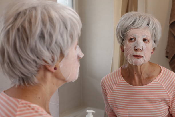istock Senior woman moisturizing her face 1567799214