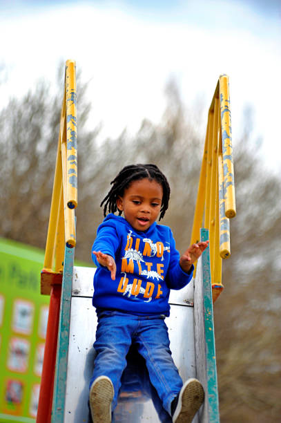istock beautiful young black African boy with dreadlocks playing in a park . 1567803109
