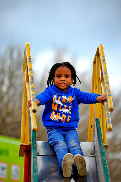 istock beautiful young black African boy with dreadlocks playing in a park . 1567808178