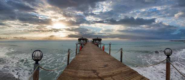 istock Seaside pier with dramatic sunset. Panorama shot. 1567813346