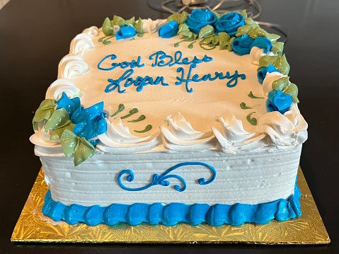 The top down view of a blue and white cake with decorative flowers on top. It says \