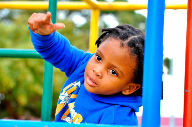 istock beautiful young black African boy with dreadlocks playing in a park . 1567818895