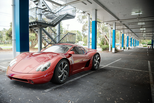 A red sports car in an undercover parking area. My own sports car design. Very high resolution 3D render.