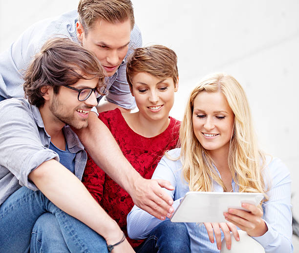 istock group of friends using digital tablet outdoors 156784257