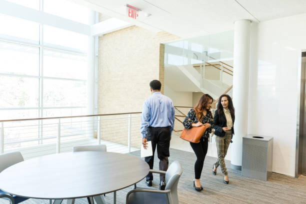 istock Businessman passes two female co-workers in second floor lobby 1567850846