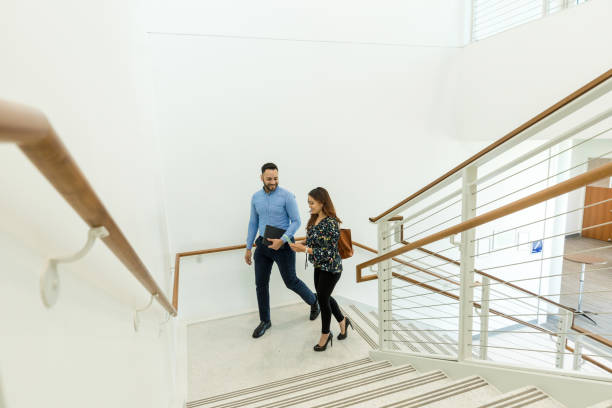 istock Ascending the stairs, co-workers discuss upcoming meeting 1567851397