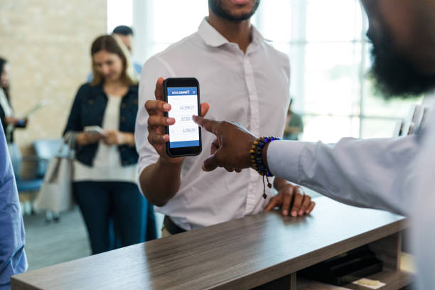 istock Unrecognizable young man shows banking app on phone to teller 1567851929