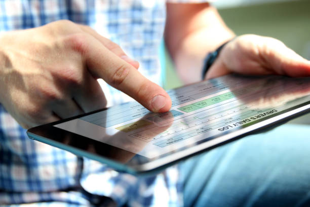 istock Truck driver checking  electronic logbooks on the tablet. 1567861429