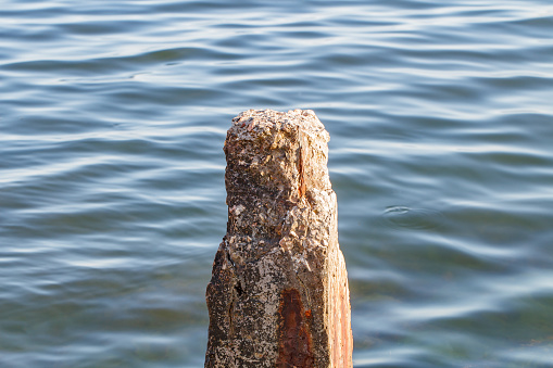 Pile pillar old concrete broken in sea close-up on clear day