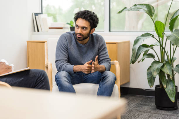 istock Young man looks to unseen therapist while sharing 1567882062