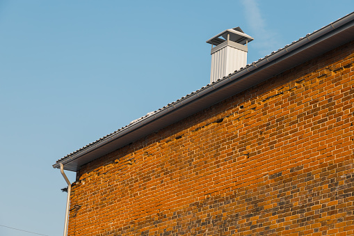 Close up chimney on roof and sky, brick wall of the house
