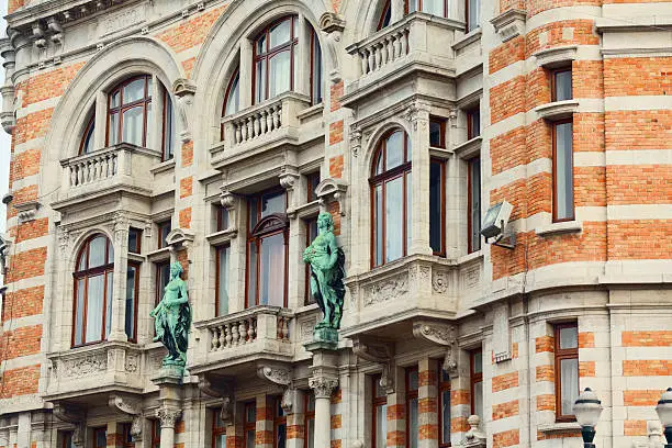 Art-Deco facade with brick, balconies and sculptures from end of 19th in Brussels Schaerbeek, Belgium.