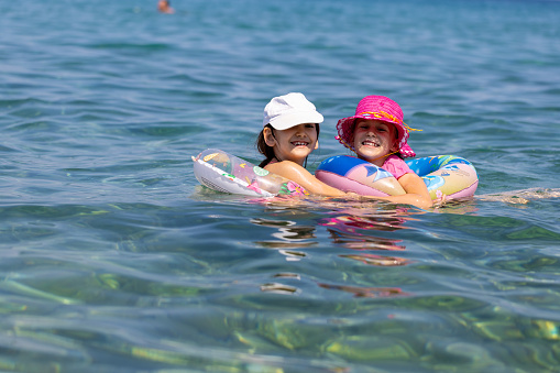 Sisters' love and laughter abound as they have a wonderful time swimming in the sea.