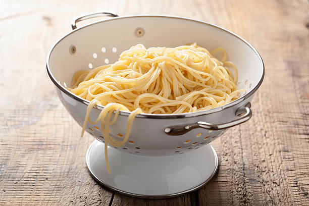 spaghetti en colander - colander photos et images de collection