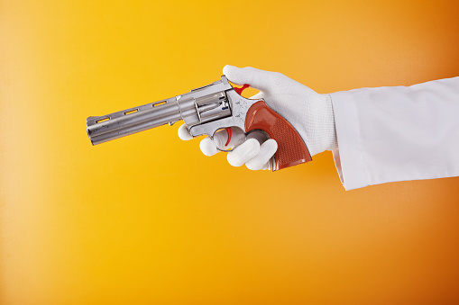 Forensic examination of a toy handgun against orange background