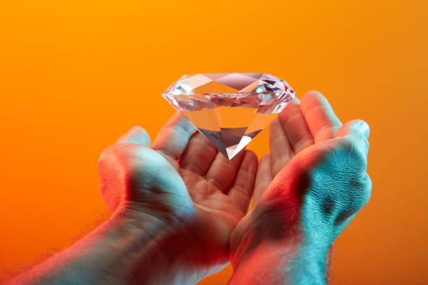 istock Beautiful sparkling diamond in hand 1567947332