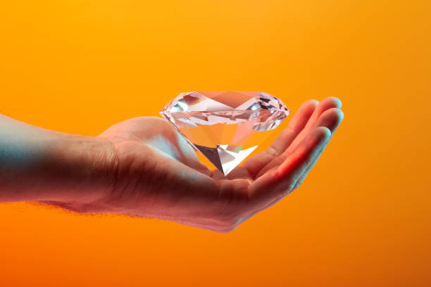 istock Beautiful sparkling diamond in hand 1567947851