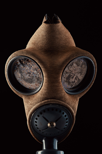 Old-fashioned military gas mask on black background