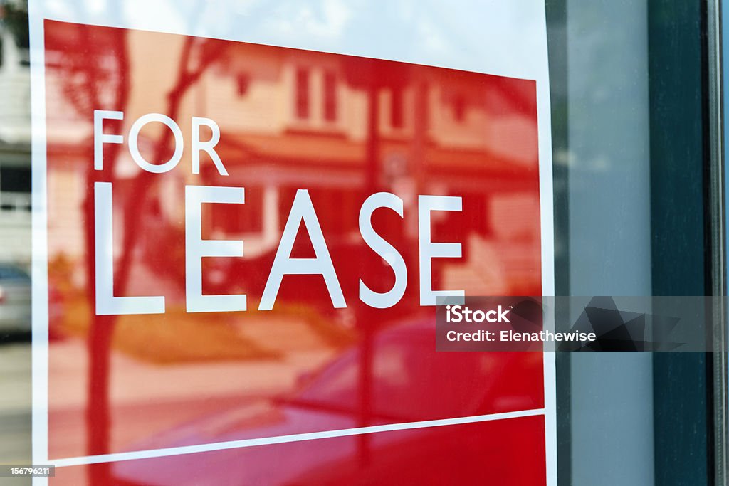For lease sign For Lease sign on red in window reflecting street scene For Lease Stock Photo