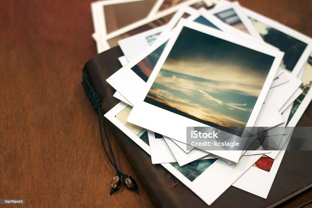 Polaroid pictures of sunset on leather journal Old polaroid pictures of a sunset piled on top of a leather journal. Instant Print Transfer Stock Photo