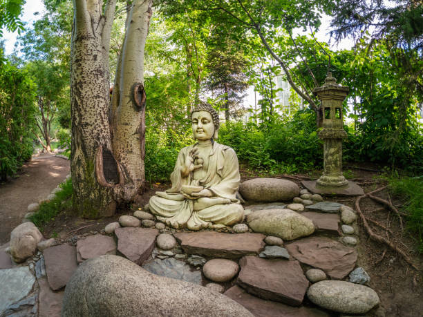 steinerne gautama buddha dekorative statue in einem garten unter grünen blättern. gartendekorationskonzept im freien. abakan - ergaki stock-fotos und bilder