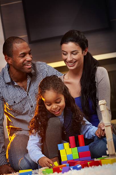 Interracial family at home playing smiling stock photo