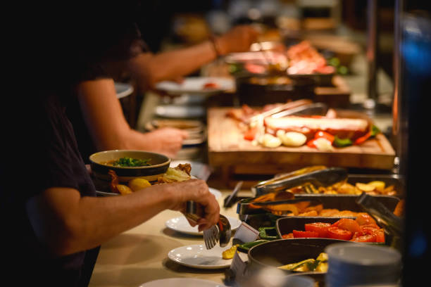 Guests of a luxury hotel take food on a buffet basis
