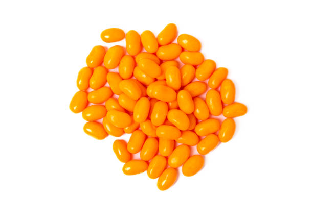 Close-up texture of orange and yellow multivitamin gummies on white background. Healthy lifestyle concept.