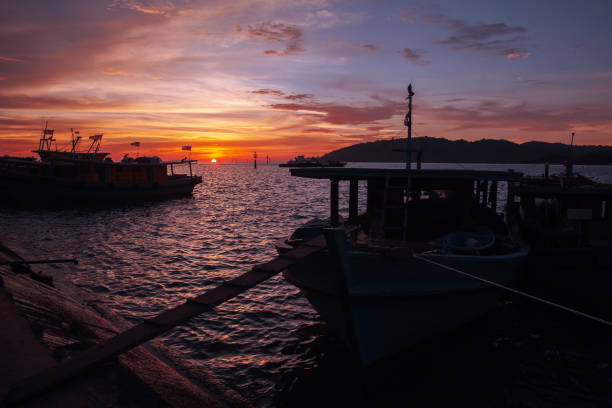 istock Fishing boats with Malaysian flags at sunset 1568011454