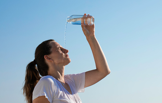 A woman cools down with cold water during the summer heat.