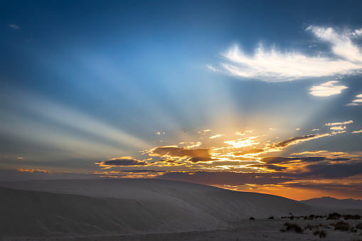 The sun sets behind the mountains at White Sands National Park near Alamogordo, New Mexico.