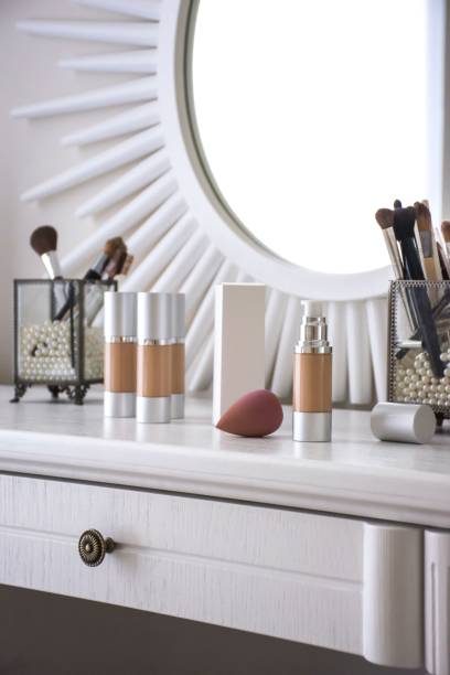 istock Assortment of cosmetics displayed on a white table top in front of a large mirror 1568045520