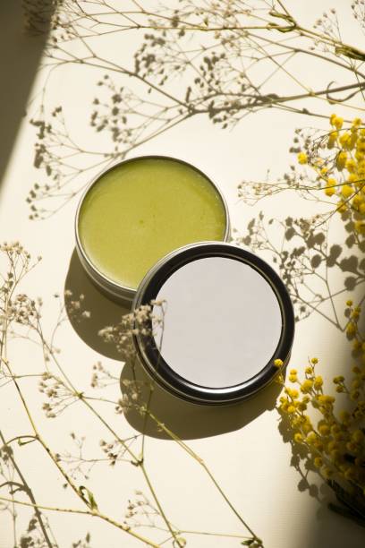 istock Silver tin filled with green balm on a table with small flowers 1568045525
