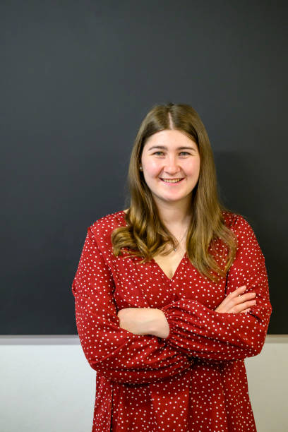 istock Smiling teacher standing at the blackboard 1568049218