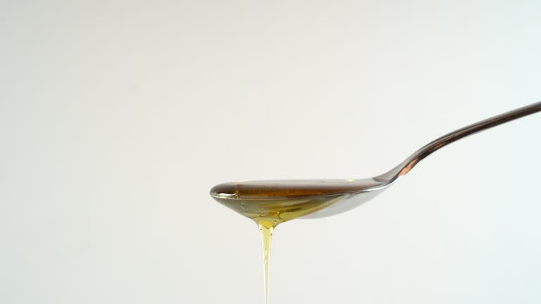 Honey flow onto a spoon until it overflows