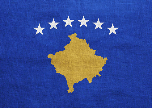 Flag of Republic of Kosovo on a textured background. Concept collage.
