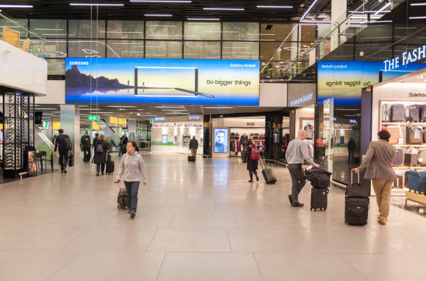 International Amsterdam Airport Schiphol Interior with Passengers. Departure Area with Duty Free Shops. Netherlands Amsterdam, Netherlands - October 18, 2017: International Amsterdam Airport Schiphol Interior with Passengers. Departure Area with Duty Free Shops. Netherlands retail digital signage stock pictures, royalty-free photos & images