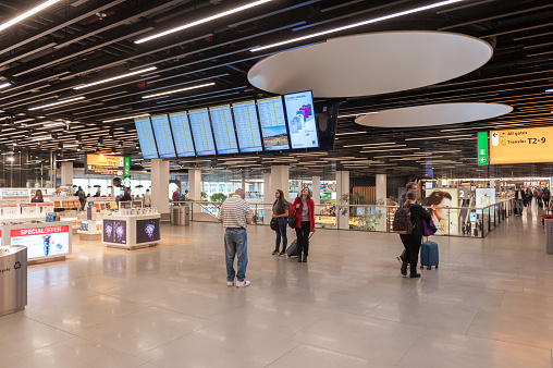 Amsterdam, Netherlands - October 18, 2017: International Amsterdam Airport Schiphol Interior with Passengers. Departure Area with Screens and Relax Zone. Netherlands