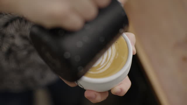 Barista making latte art at a cafe