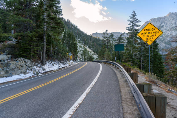 istock Warning sign on a curvy mountain road at sunset 1568143753