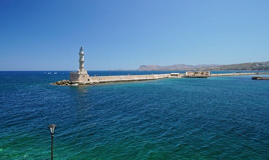 Iconic Egyptian Lighthouse at Old Venetian Port of Rethymno, Crete island Greece. Beacon, stonewall building, sea water, blue sky, summer holiday.