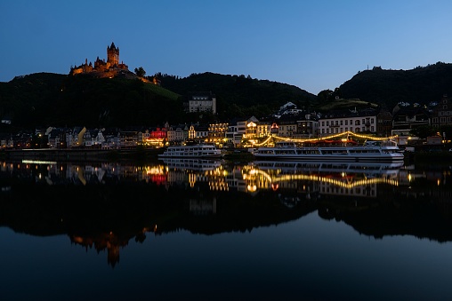 Cochem, Germany – June 25, 2023: A beautiful shot of the illuminated pier and buildings in the evening in Cochem, Germany